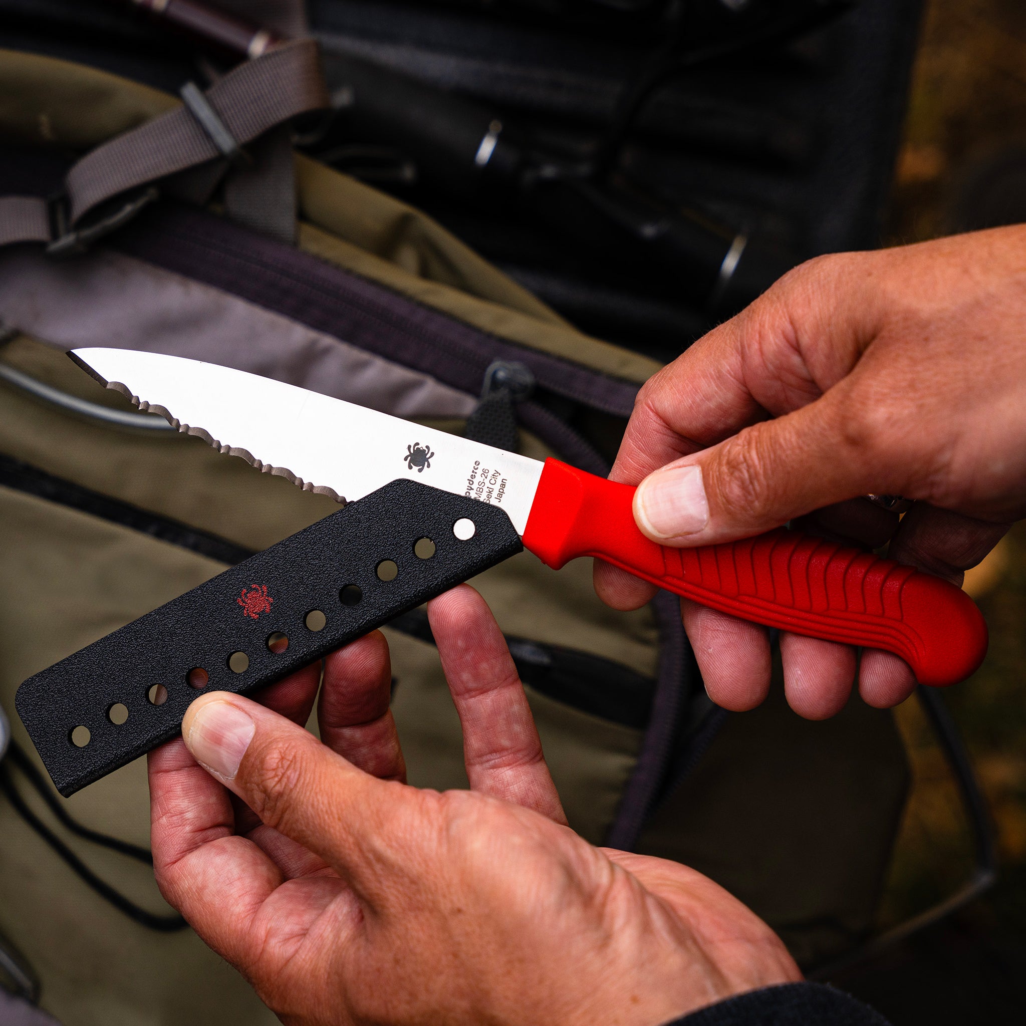 A knife being placed into a sharpkeeper blade guard.